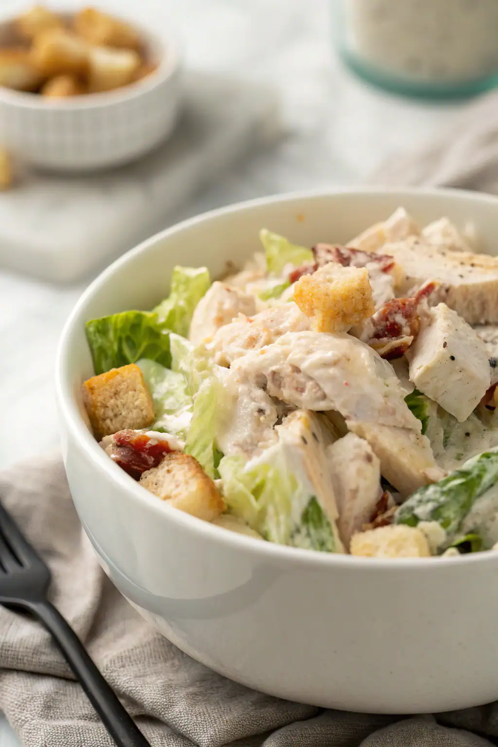 Chicken salad with creamy dressing and fresh herbs in white bowl, perfectly garnished for an appetizing presentation