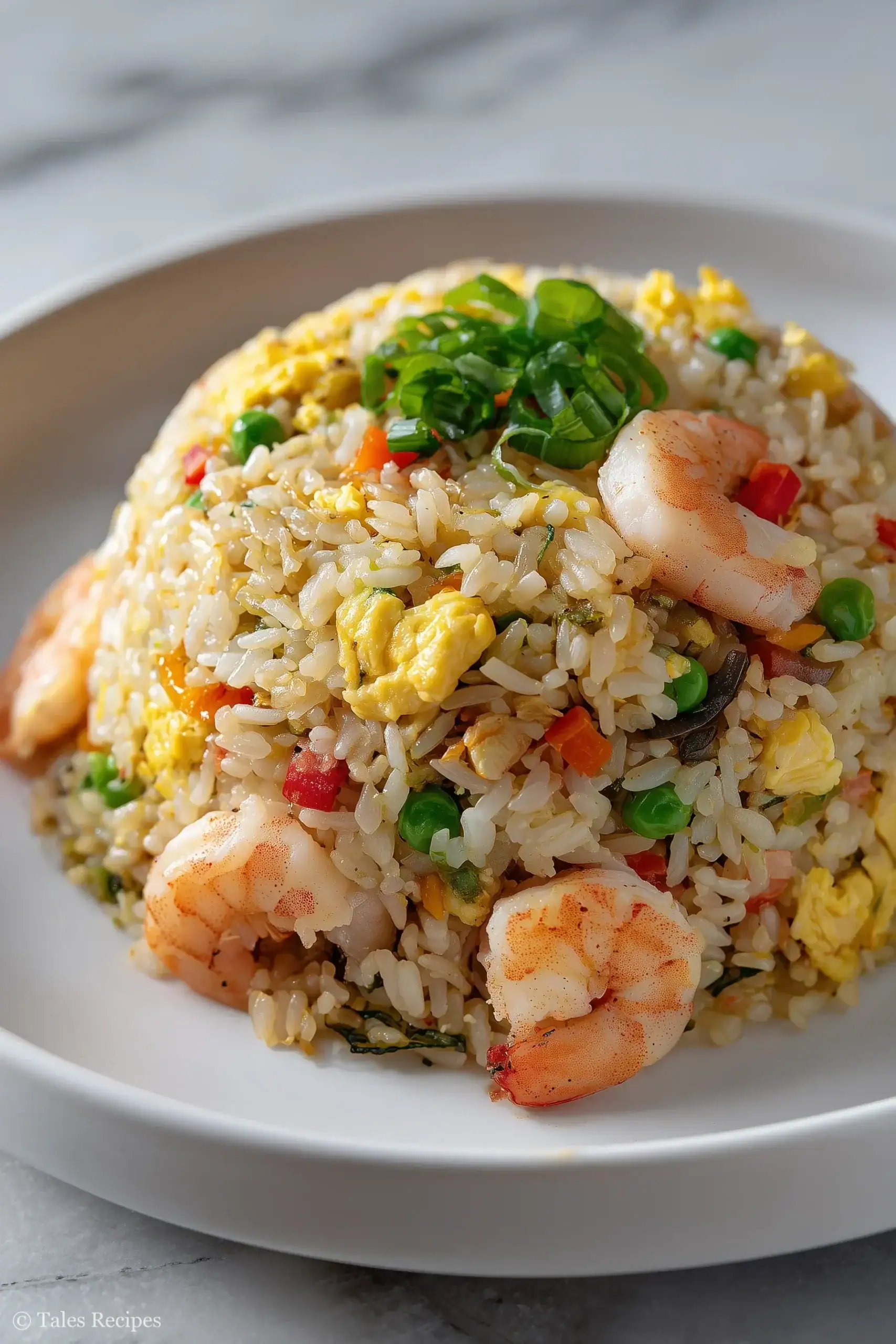Freshly cooked blackstone fried rice with shrimp and colorful vegetables on a white plate